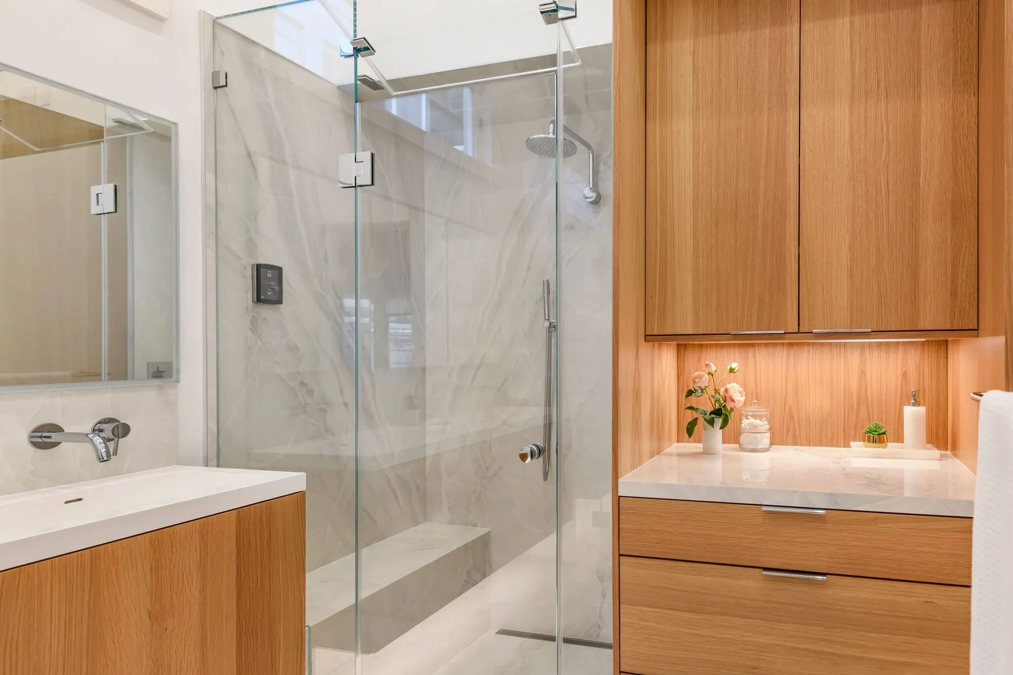 Modern bathroom with glass shower and wood cabinetry