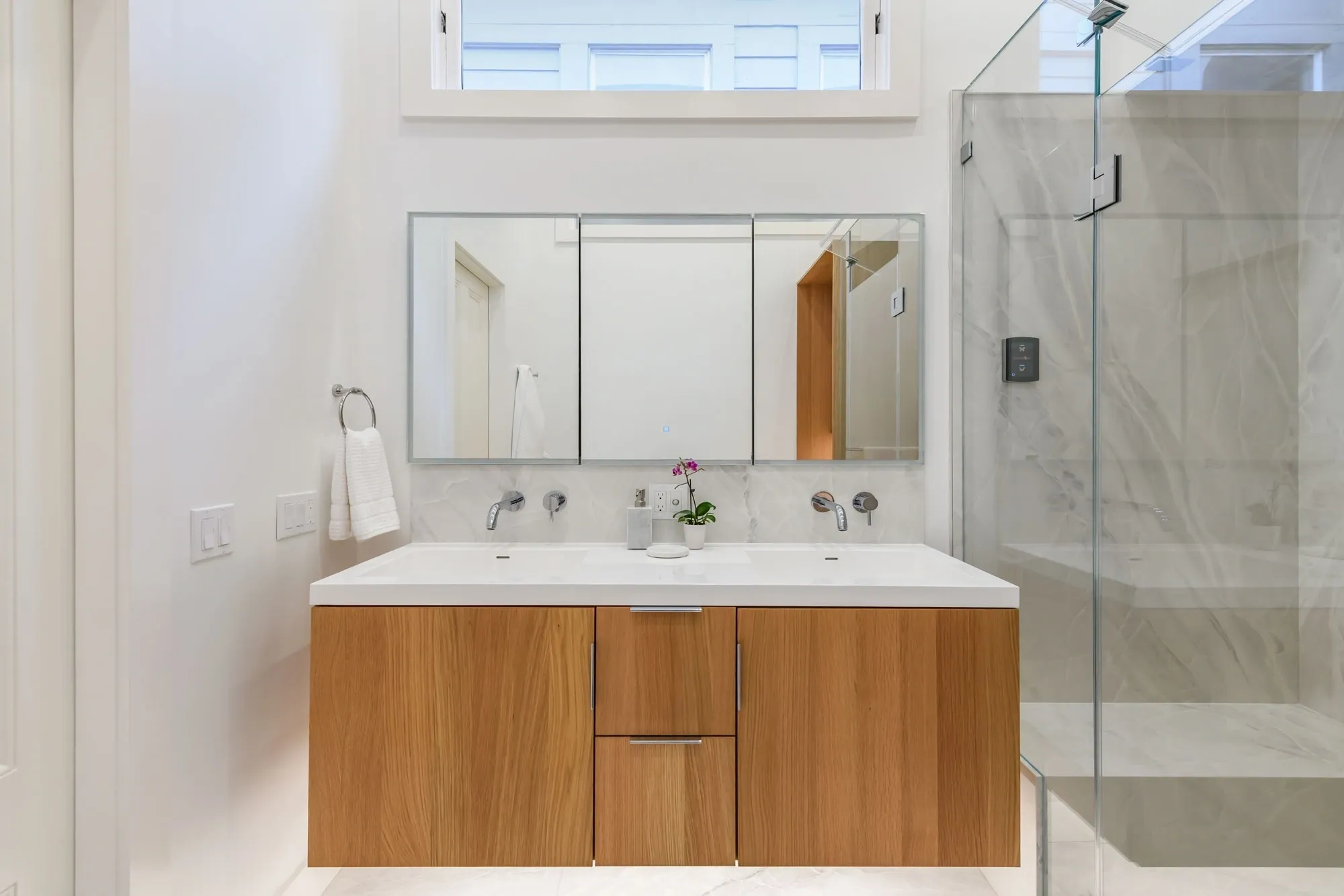 Modern bathroom with wooden vanity and glass shower