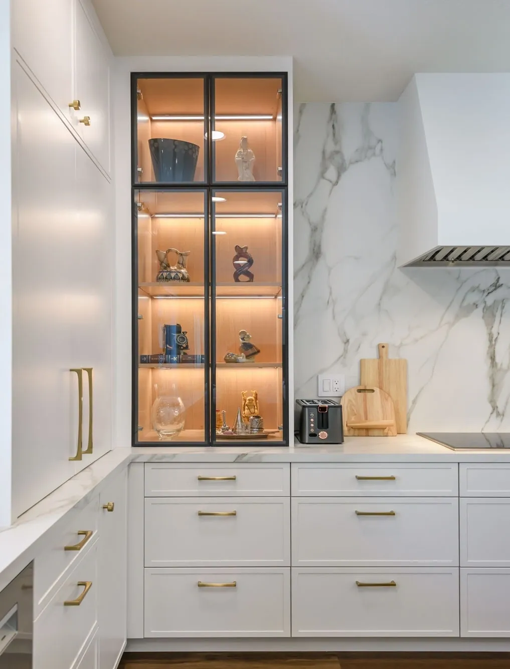 White kitchen with lit glass display cabinet