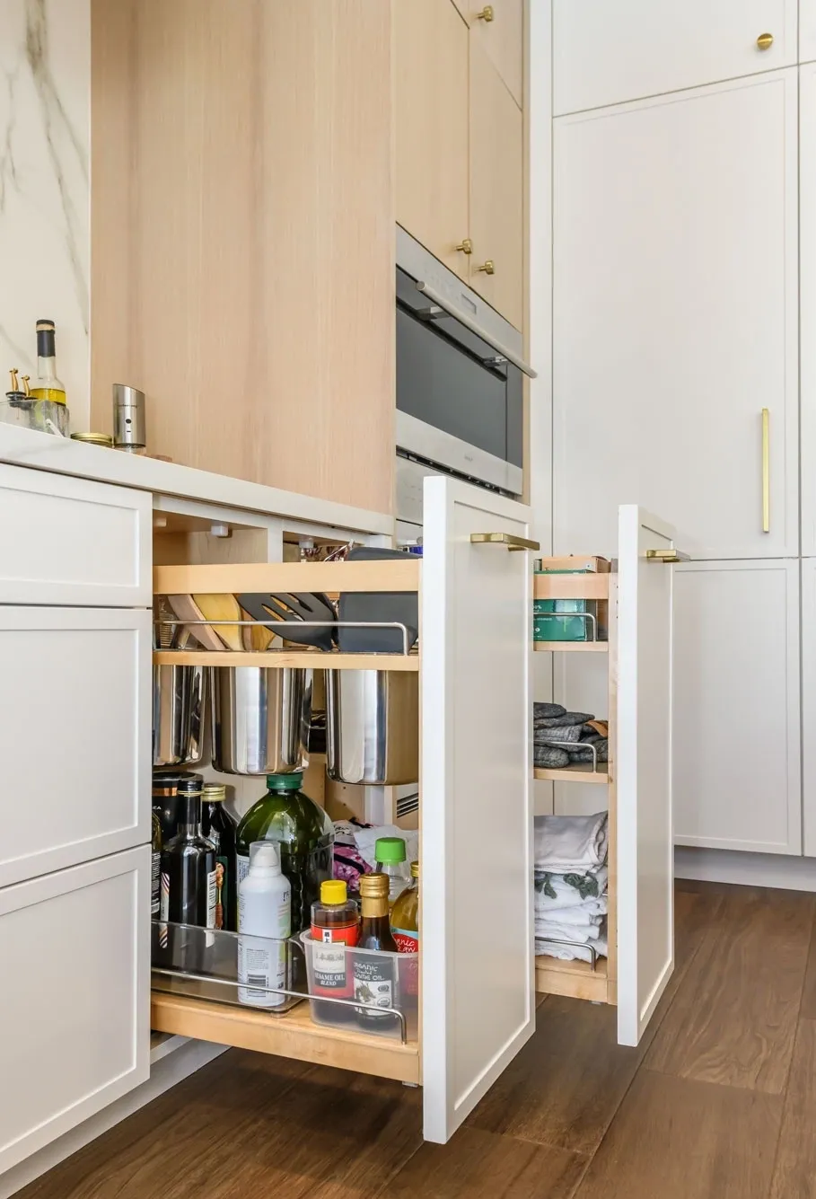 Pull-out kitchen cabinet with cookware and condiments