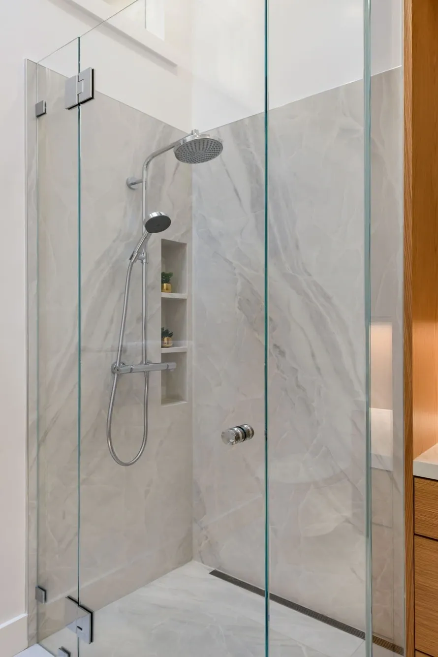 Frameless glass marble shower with rain showerhead