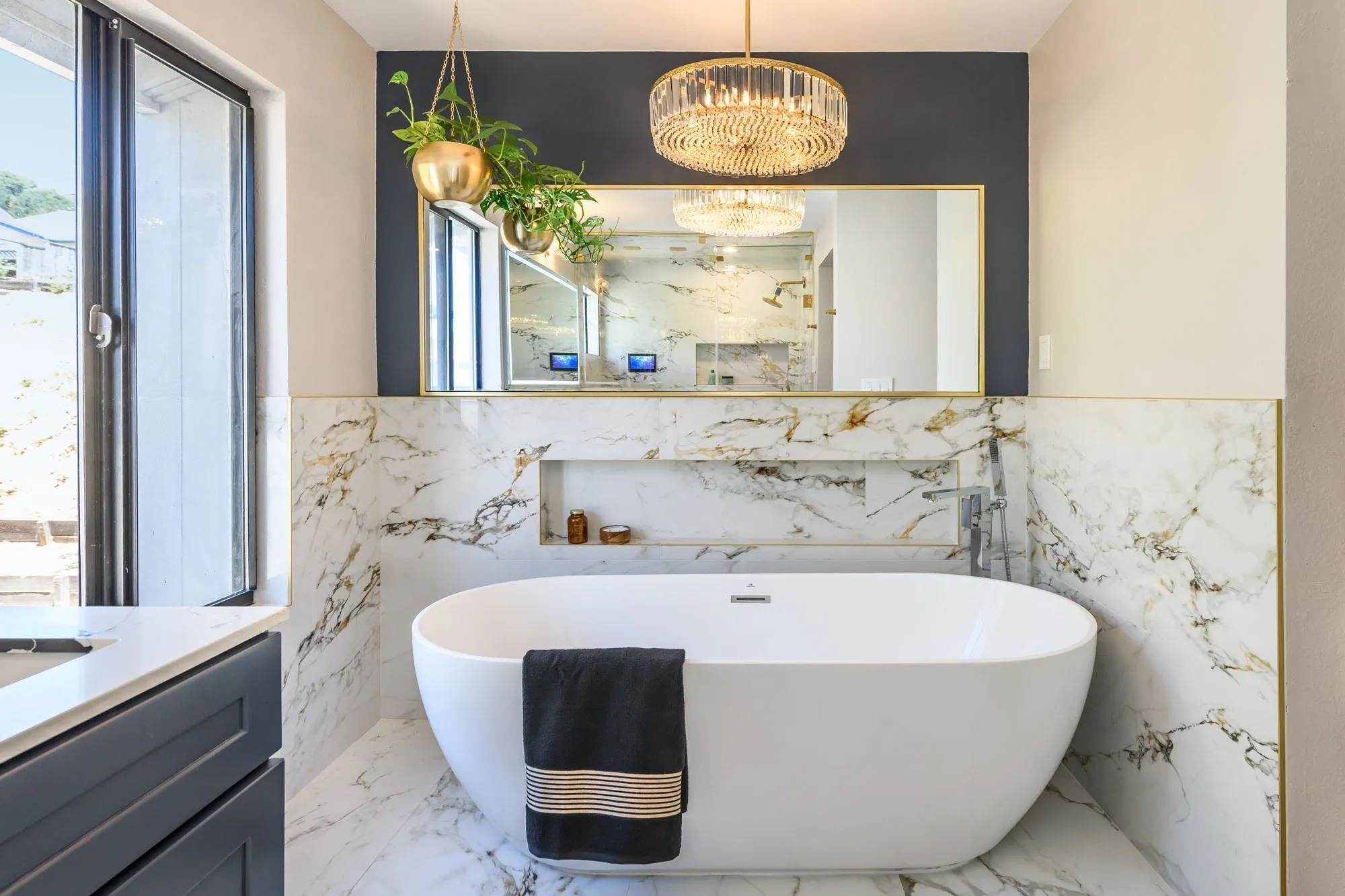 Marble bathroom with freestanding tub and chandelier